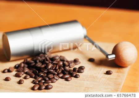 Shiny modern manual coffee grinder and beans Shiny modern manual coffee grinder and beans 65766478