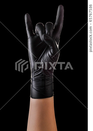 Hand in black gloves showing rock n roll sign or Hand in black gloves showing rock n roll sign or 65767586