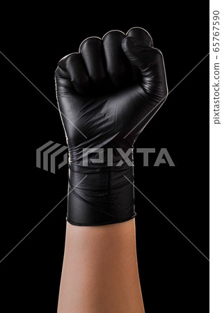 Hand in black gloves showing clenched fist Hand in black gloves showing clenched fist 65767590