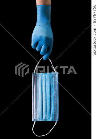 Doctor's hand in medical gloves wearing a mask 65767756