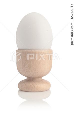 Chicken egg in holder isolated on white. 65768013