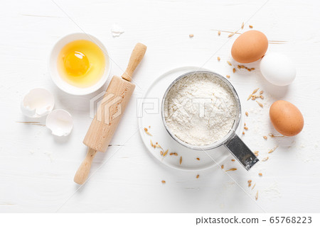 Flour and eggs on white kitchen worktop, baking 65768223