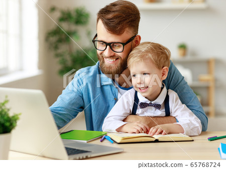 Father helping child with online lesson at home. 65768724