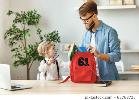 Father and kid preparing school backpack 65768725