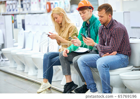 warehouse worker and customers sit on toilet bowl 65769196
