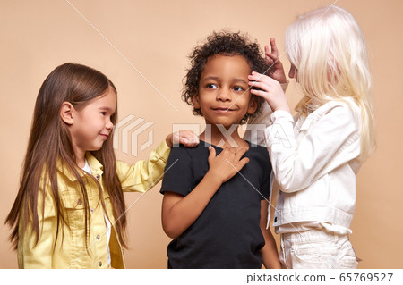 sweet kid girls play with african dark-skinned boy 65769527