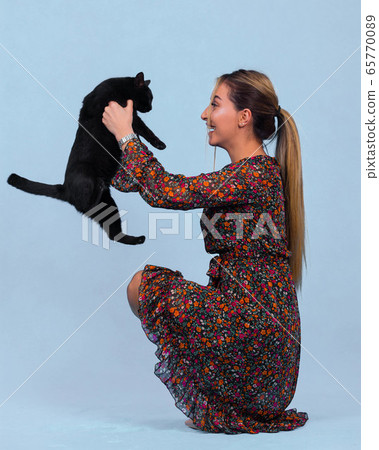 pretty young girl holds a black cat in her arms pretty young girl holds a black cat in her arms 65770089