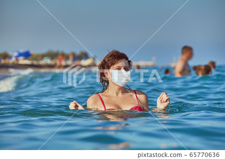 Relaxing during sea season in medical mask. 65770636