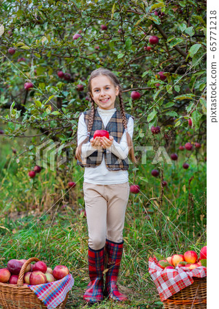 Portrait of a cute girl in a farm garden with a Portrait of a cute girl in a farm garden with a 65771218