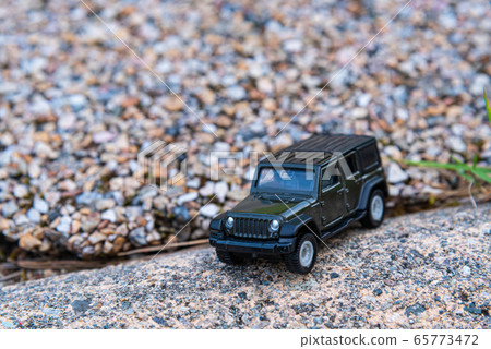 在崎rough不平的道路上行駛的汽車 65773472