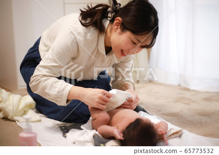 媽媽換嬰兒的尿布 媽媽換嬰兒的尿布 65773532