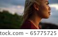 Profile of young woman takes in a sunset while on vacation  65775725