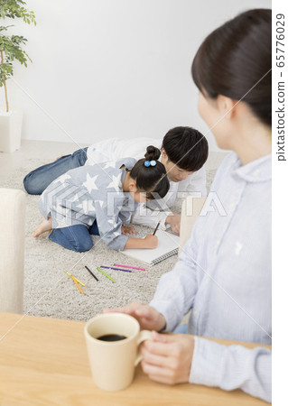 A mother watching over her elementary school girl who starts painting with her father 65776029