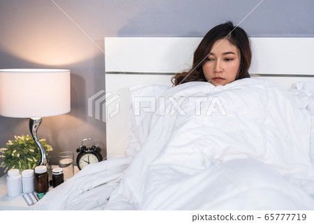 sick woman feeling cold in blanket on bed at home 65777719