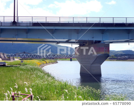 Shinkansen, orange railway bridge and flower garden on the riverbank Shinkansen, orange railway bridge and flower garden on the riverbank 65778090