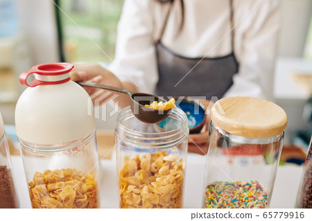 Waiter filling bowl with cornflakes 65779916