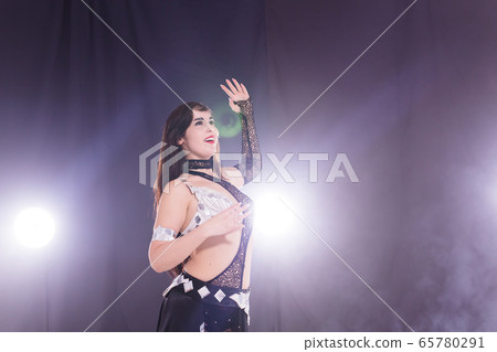Young woman dancing in Tribal Fusion style. Belly dance on the stage. Young woman dancing in Tribal Fusion style. Belly dance on the stage. 65780291