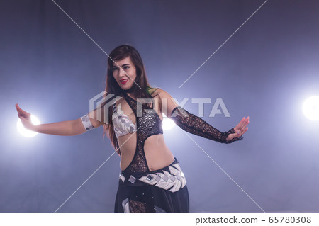 Young woman dancing in Tribal Fusion style. Belly dance on the stage. 65780308