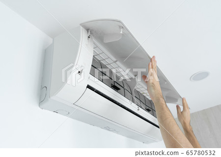 The guy cleans the filter of the home air 65780532