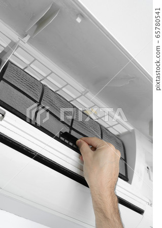 The guy cleans the filter of the home air The guy cleans the filter of the home air 65780541