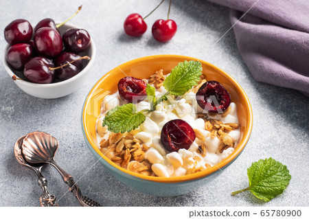 Grain curd muesli with fresh cherries on a plate. Concept healthy Breakfast with cottage cheese and berries. 65780900