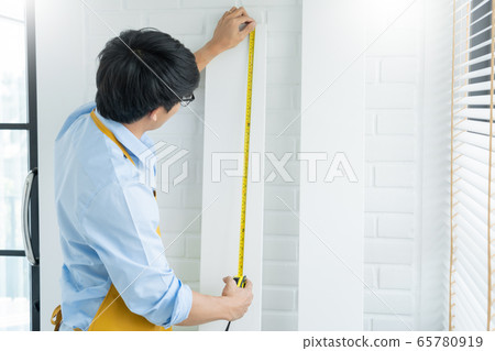 Men's hands hold a measuring tape measuring with Men's hands hold a measuring tape measuring with 65780919