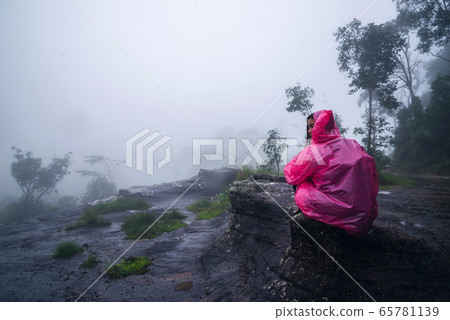 tourist with pink rain coat Sitting View the scenery natural beautiful touch fog tourist with pink rain coat Sitting View the scenery natural beautiful touch fog 65781139