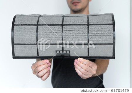 The guy cleans the filter of the home air 65781479