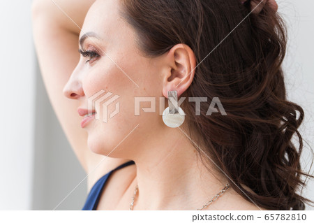 Close-up portrait of beautiful young woman with elegant hairstyle and luxurious jewelry and bijouterie. Close-up portrait of beautiful young woman with elegant hairstyle and luxurious jewelry and bijouterie. 65782810