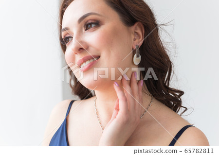 Elegant woman with earrings, close up portrait. Accessories, jewelry and bijouterie concept. Elegant woman with earrings, close up portrait. Accessories, jewelry and bijouterie concept. 65782811
