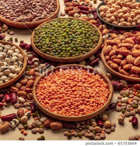 Legumes assortment on a brown background. Lentils, soybeans, chickpeas, red kidney beans, a vatiety of pulses, square shot Legumes assortment on a brown background. Lentils, soybeans, chickpeas, red kidney beans, a vatiety of pulses, square shot 65783664