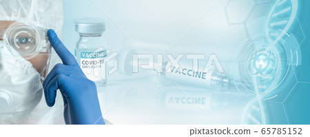 Doctor in a protective suit against the background of a syringe with the inscription Vaccine Doctor in a protective suit against the background of a syringe with the inscription Vaccine 65785152