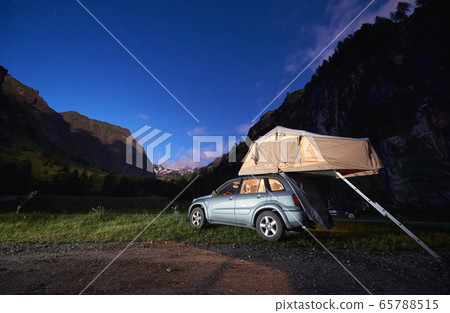 Car with rooftop camping tent in mountains. 65788515