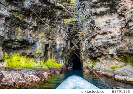 Rubber boat entering dark cave near the ocean Rubber boat entering dark cave near the ocean 65791156