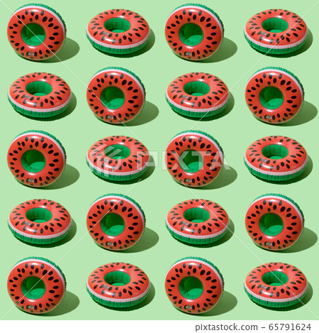 Red inflatable watermelons on a green background Red inflatable watermelons on a green background 65791624