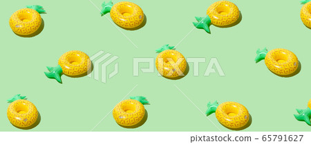 Yellow inflatable pineapples on a green background Yellow inflatable pineapples on a green background 65791627