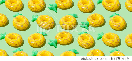 Yellow inflatable pineapples on a green background Yellow inflatable pineapples on a green background 65791629