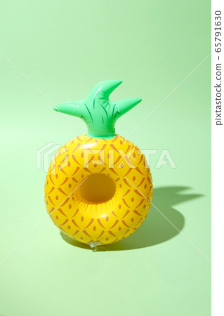 Yellow inflatable pineapples on a green background Yellow inflatable pineapples on a green background 65791630