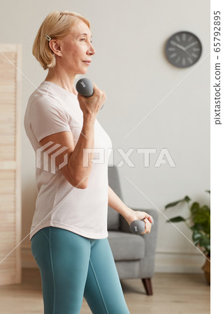 Woman training with dumbbells 65792895