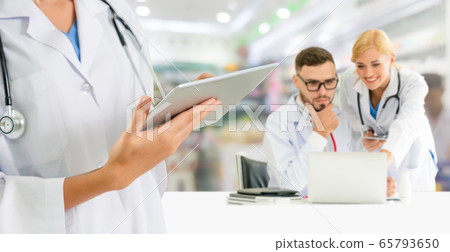 Doctor working in hospital with other doctors. Doctor working in hospital with other doctors. 65793650