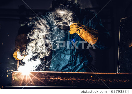 Metal welder working with arc welding machine. Metal welder working with arc welding machine. 65793884