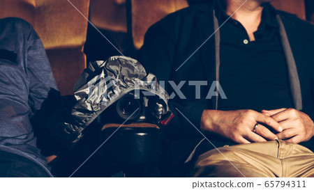A man is secretly filming while watching a movie. 65794311