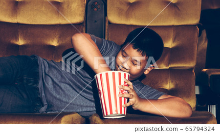 The boy is laying down watching movies. The boy is laying down watching movies. 65794324