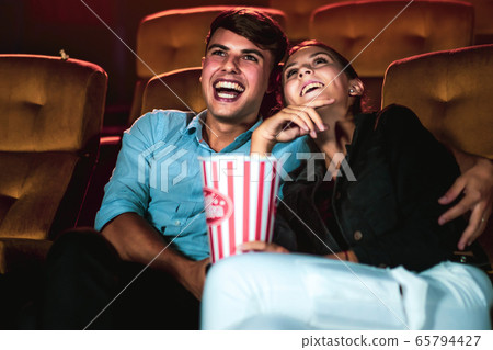 Man and woman watching movie in cinema theater. 65794427
