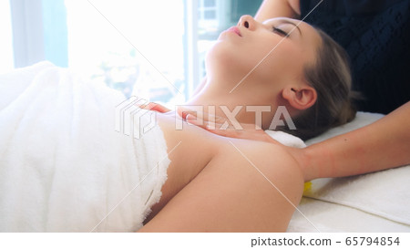 Woman gets shoulder massage spa by therapist. 65794854