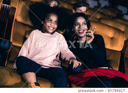 Woman enjoy to watch a movie with her daughter Woman enjoy to watch a movie with her daughter 65794917