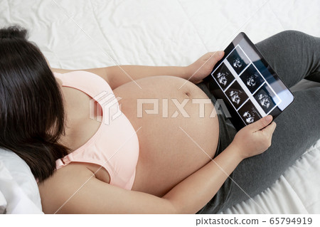 Happy pregnant woman and expecting baby at home. Happy pregnant woman and expecting baby at home. 65794919
