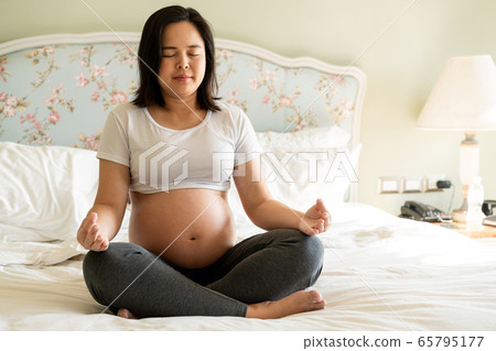 Happy pregnant woman and expecting baby at home. Happy pregnant woman and expecting baby at home. 65795177