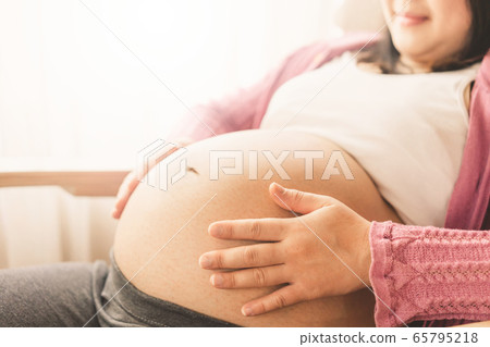 Happy pregnant woman and expecting baby at home. Happy pregnant woman and expecting baby at home. 65795218