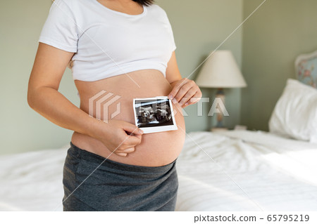 Happy pregnant woman and expecting baby at home. Happy pregnant woman and expecting baby at home. 65795219